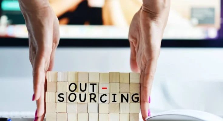Entrepreneur evaluating outsourcing options for business growth