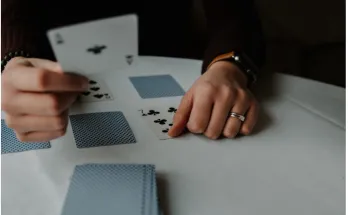 Player squeezing a card during a live Baccarat game, enhancing excitement and strategy.